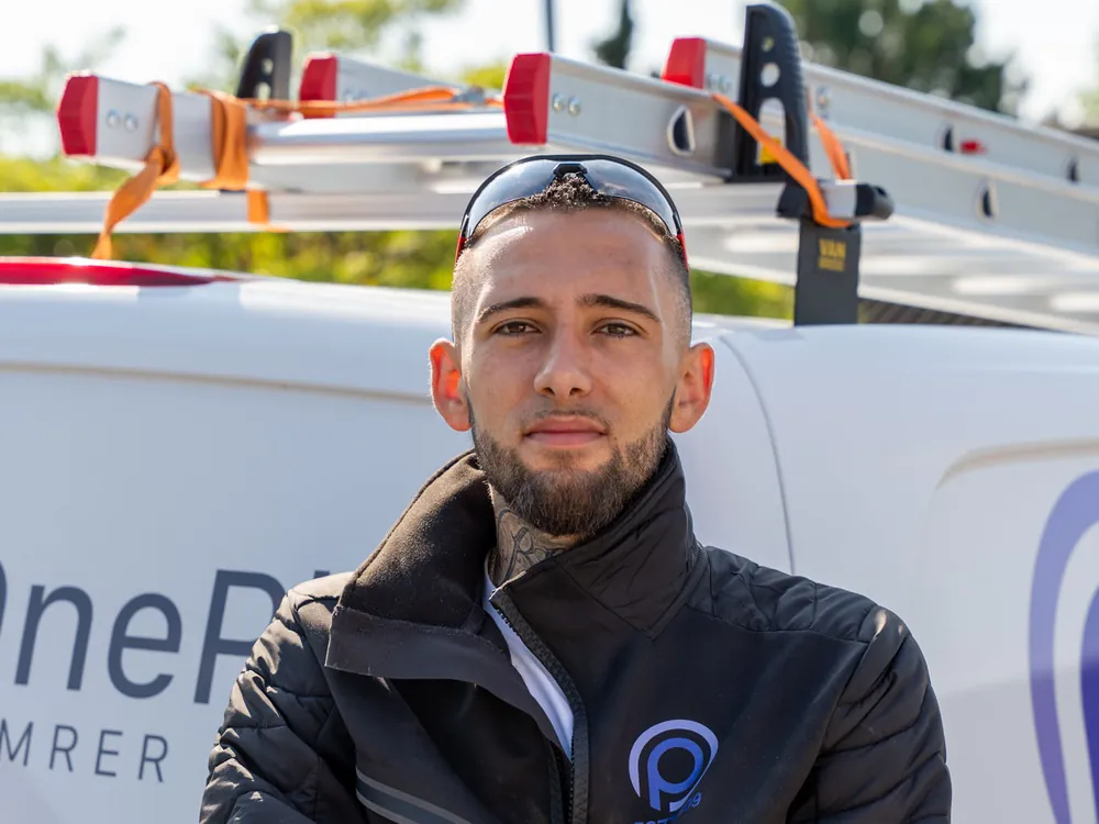 Håndværker fra OnePlan ApS foran firmabilen