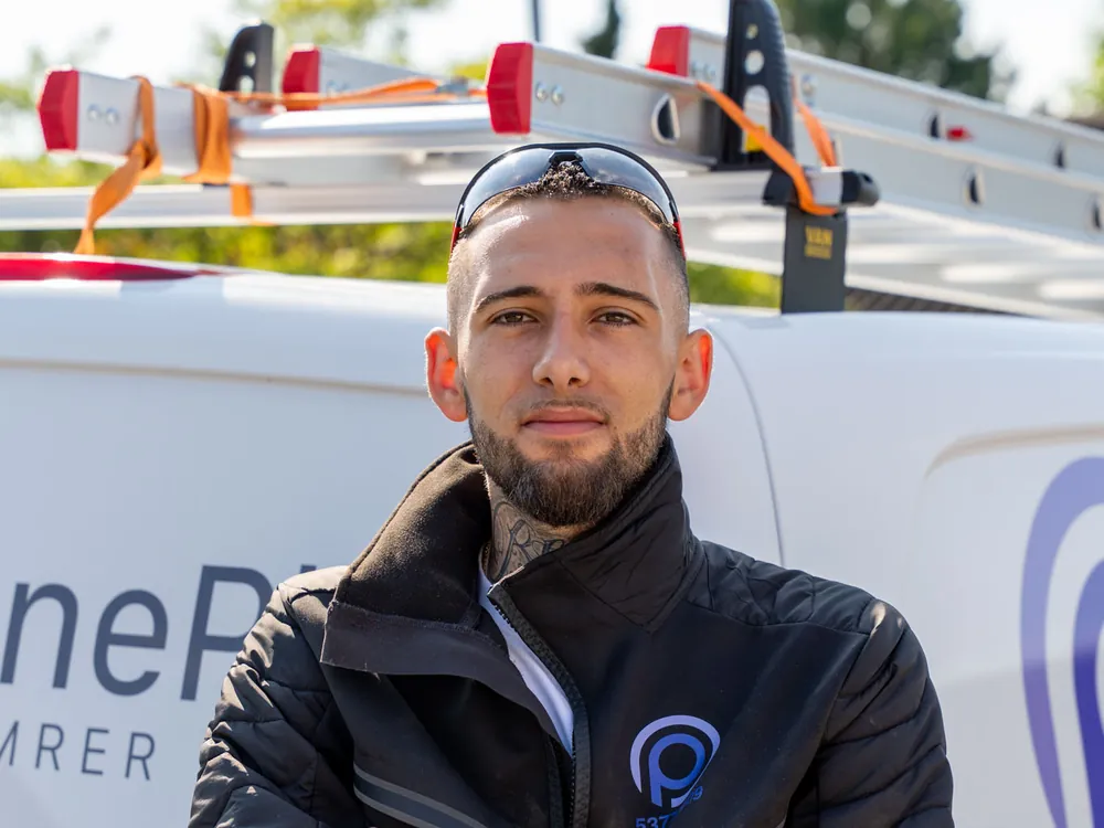 Håndværker fra OnePlan ApS ved firmabilen