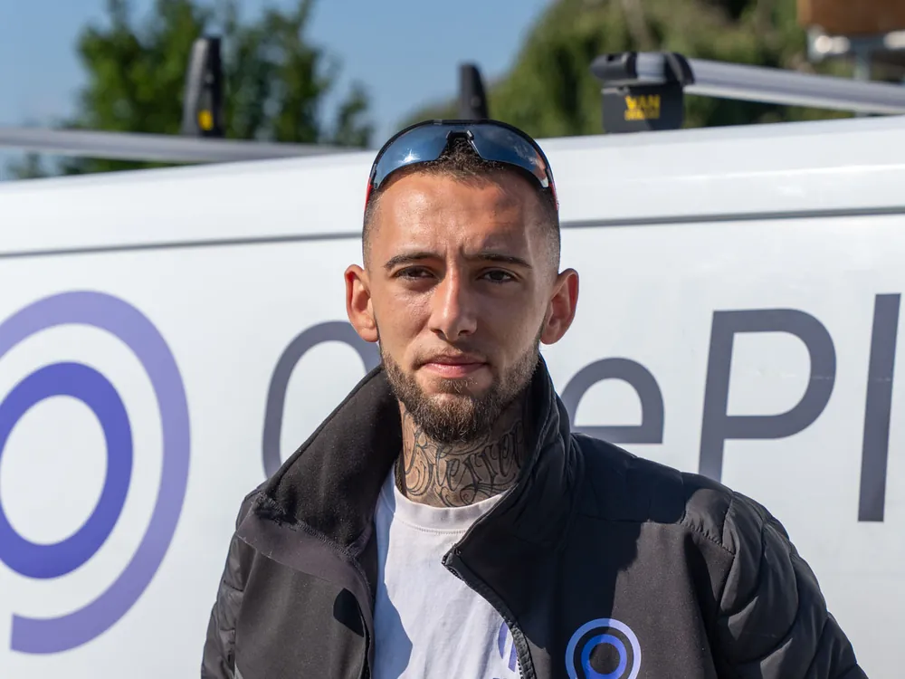 Håndværker fra OnePlan ApS ved firmabilen