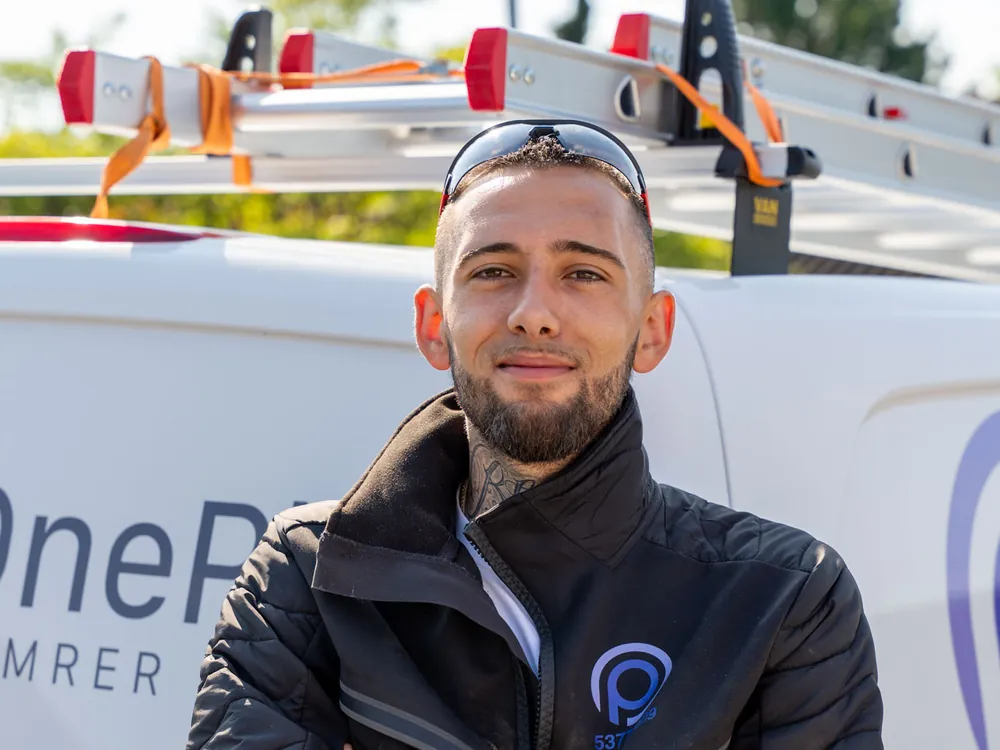 Håndværker fra OnePlan ApS foran firmabilen