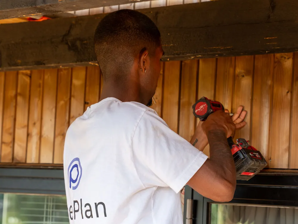 Håndværker fra OnePlan ApS arbejder på ydervæggen