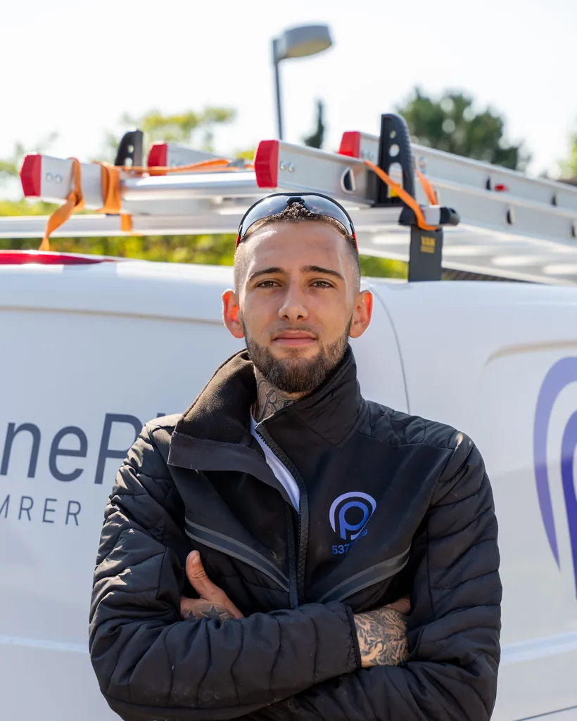 Håndværker fra OnePlan ApS ved firmabilen
