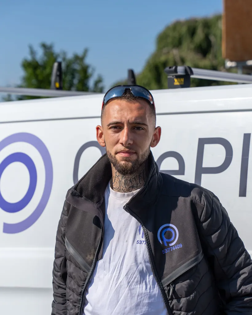 Håndværker fra OnePlan ApS ved firmabilen