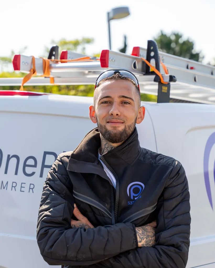 Håndværker fra OnePlan ApS foran firmabilen