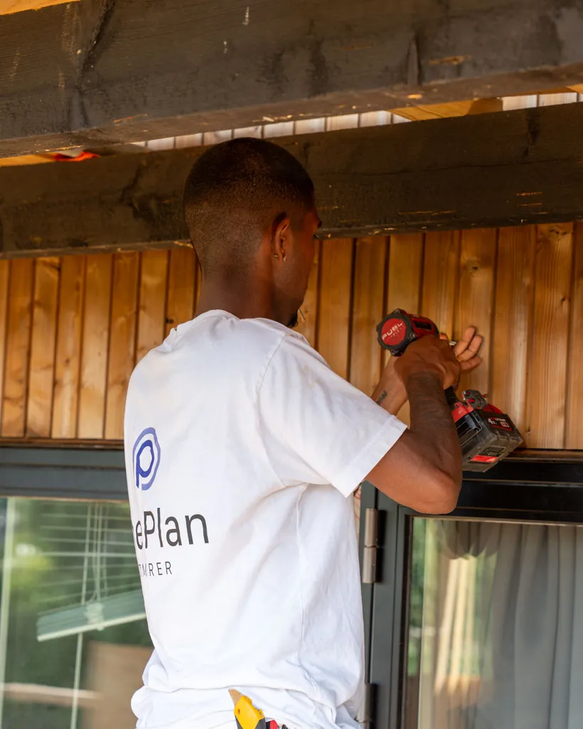 Håndværker fra OnePlan ApS arbejder på ydervæggen